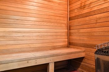 a wooden sauna with a bench and stove